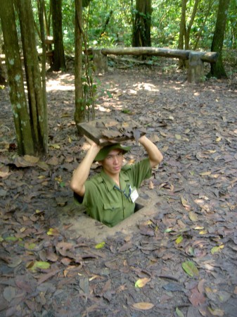 Vietnamese Man Demonstrates Tunnel Entrance 1