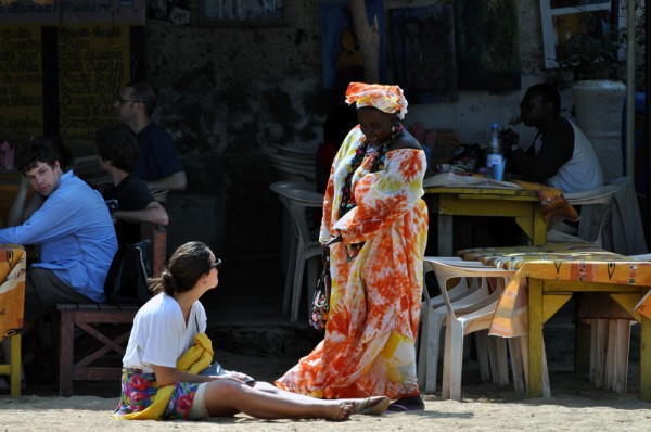 A colorfully dressed woman talks to a tourist on Goree Island in Senegal