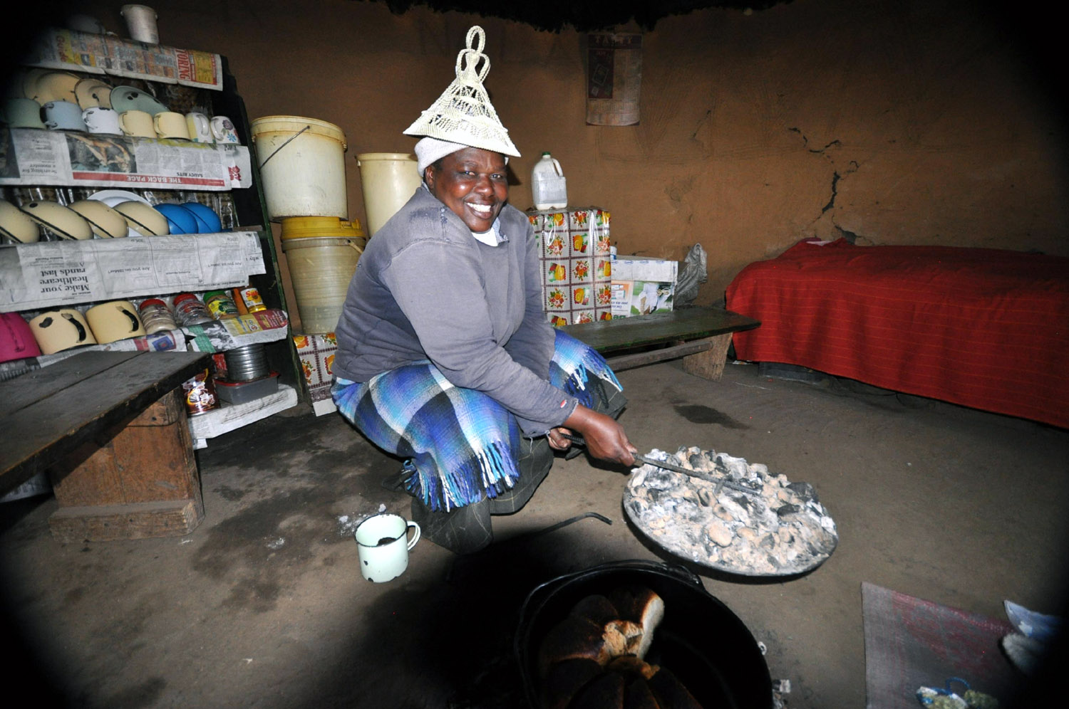 Basotho woman in Lesotho cooking bread over the fire