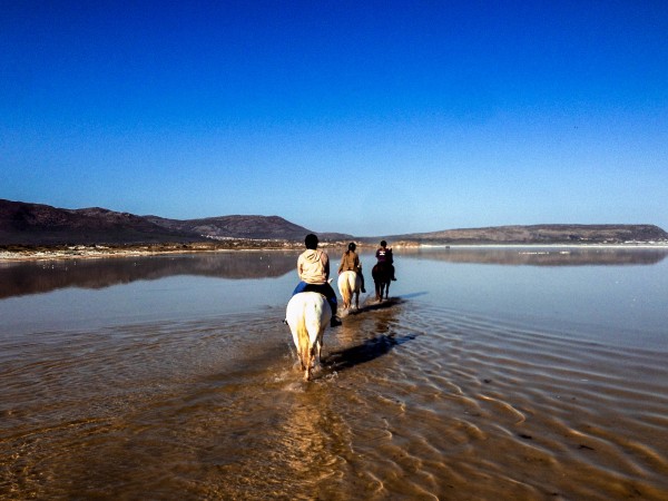 Riding across the shallow waters of Nordhoek beach