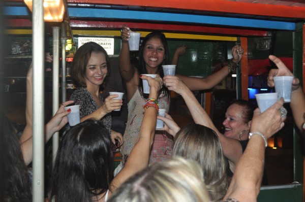 Girls toast their drinks as the Chiva rolls through town