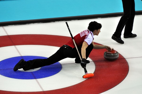 Russia's Ekaterina Galkina prepares to deliver a curling stone against the USA