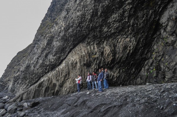 My friends and I perched on the edge of the giant basalt cave at Reynisfjara with the ocean crashing nearby.