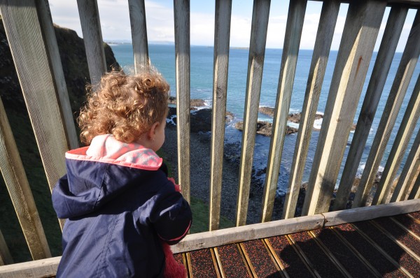 Our daughter looking out at the crashing waves below Dunluce Castle.