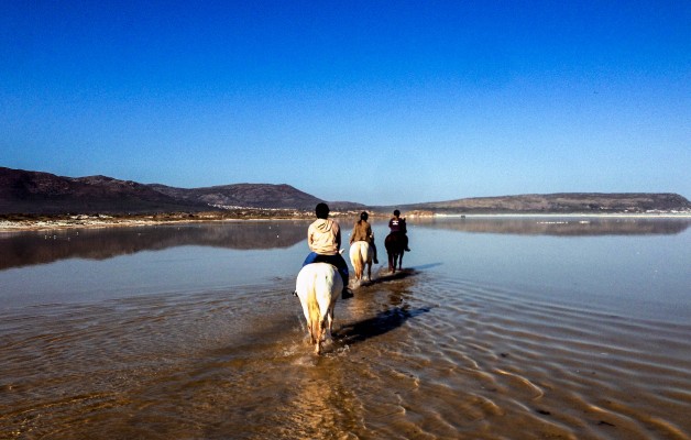 Riding across the shallow waters of Nordhoek beach