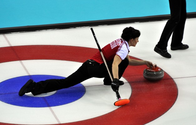 Russia's Ekaterina Galkina prepares to deliver a curling stone against the USA